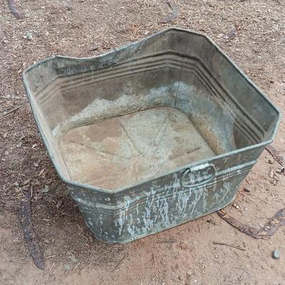Metal wash tub with two vintage pickaxe heads