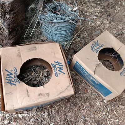 Partial roll of barbed wire and two partial boxes of HW Brand Bailing wire