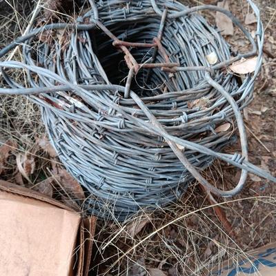Partial roll of barbed wire and two partial boxes of HW Brand Bailing wire