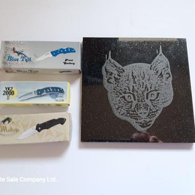 Laser art tile of a bobcat and three new pocketknives