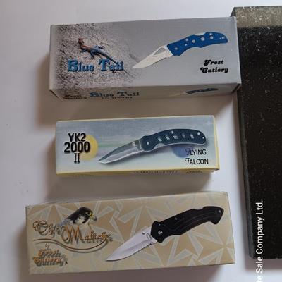 Laser art tile of a bobcat and three new pocketknives
