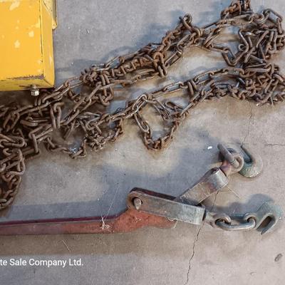 Yellow metal toolbox for tractor with assortment of chain and a chain binder