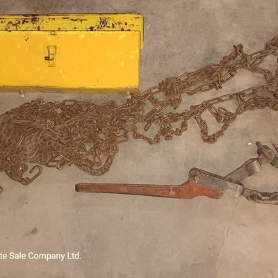 Yellow metal toolbox for tractor with assortment of chain and a chain binder