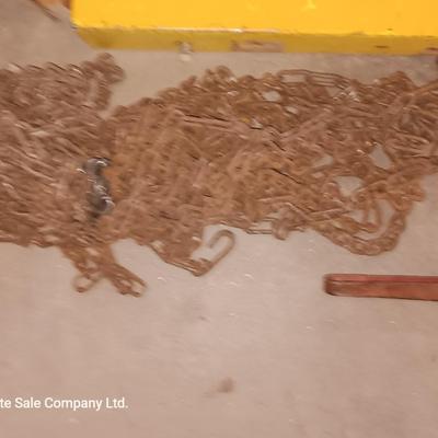 Yellow metal toolbox for tractor with assortment of chain and a chain binder