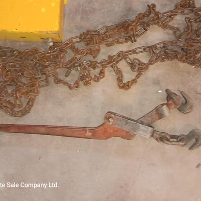 Yellow metal toolbox for tractor with assortment of chain and a chain binder