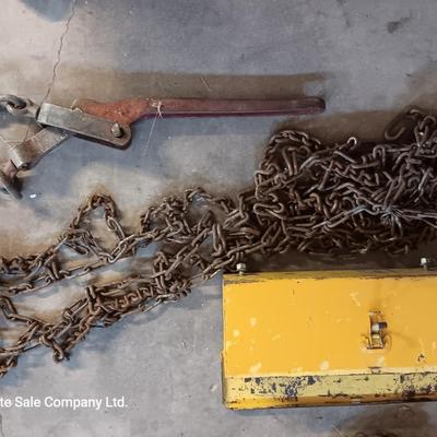 Yellow metal toolbox for tractor with assortment of chain and a chain binder