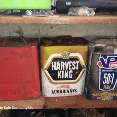Vintage tin cans partially full of chemicals with metal bucket