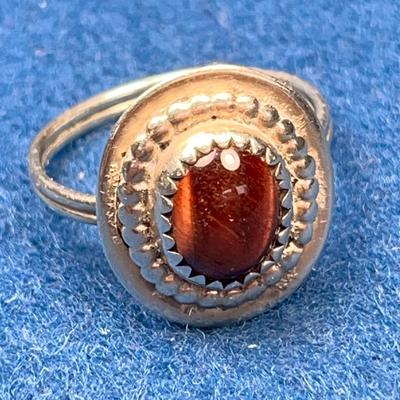 UNMARKED SILVER RING WITH INSET BROWN IRIDESCENT STONE