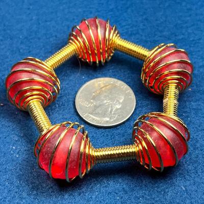 UNUSUAL COILED GOLDTONE BRACELET WITH RED ENCASED BEADS