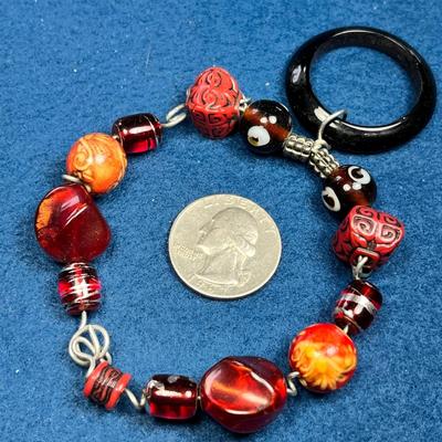 FANCY RED BEAD BRACELET WITH BLACK DANGLY RING
