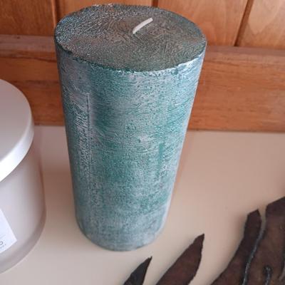 Saw blade pine tree art with candles scented candle in a jar and pillar candle.