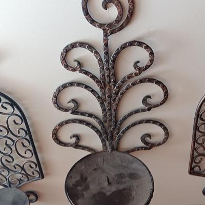 Three metal candle sconces with elegant votive candles