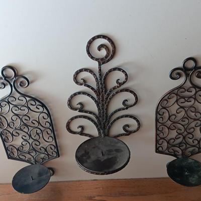 Three metal candle sconces with elegant votive candles