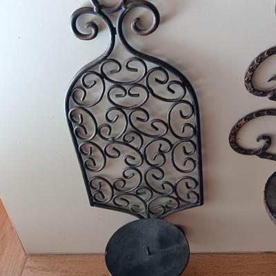 Three metal candle sconces with elegant votive candles