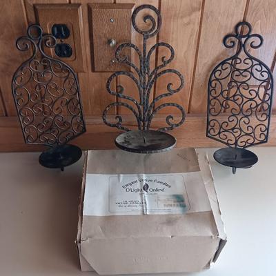 Three metal candle sconces with elegant votive candles