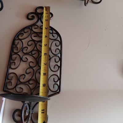 Three metal candle sconces with elegant votive candles