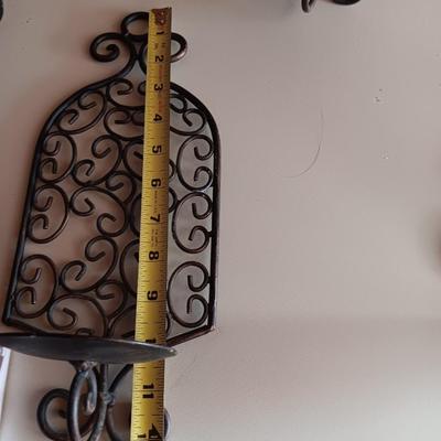 Three metal candle sconces with elegant votive candles
