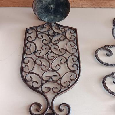 Three metal candle sconces with elegant votive candles