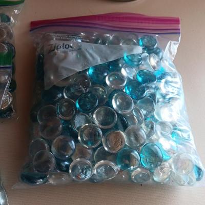 Two tall clear vases with blue toned and clear glass pebbles