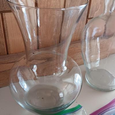 Two tall clear vases with blue toned and clear glass pebbles