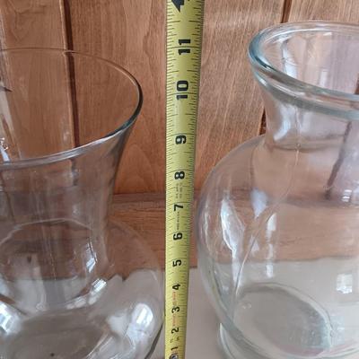 Two tall clear vases with blue toned and clear glass pebbles