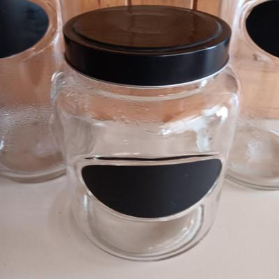 Three glass canisters with lids and chalkboard label area