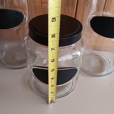 Three glass canisters with lids and chalkboard label area