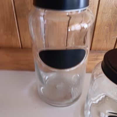 Three glass canisters with lids and chalkboard label area