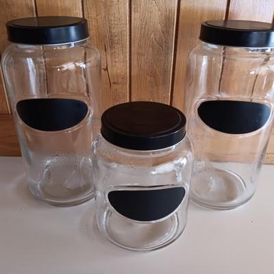 Three glass canisters with lids and chalkboard label area
