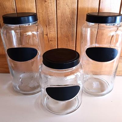 Three glass canisters with lids and chalkboard label area