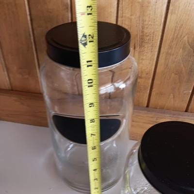 Three glass canisters with lids and chalkboard label area