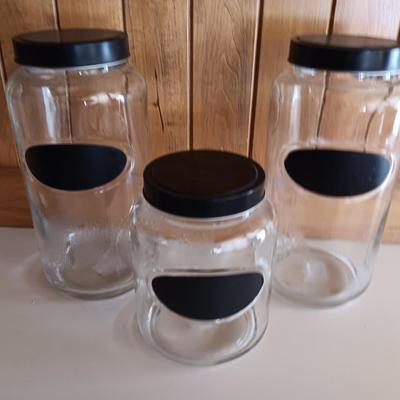 Three glass canisters with lids and chalkboard label area