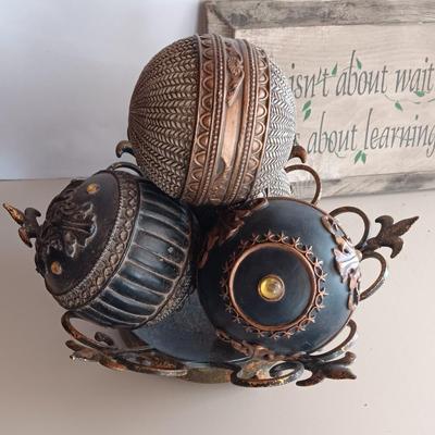 Metal Fleur De Lis accented dish with 4 large decorative balls and a sawdust city wood sign with saying.