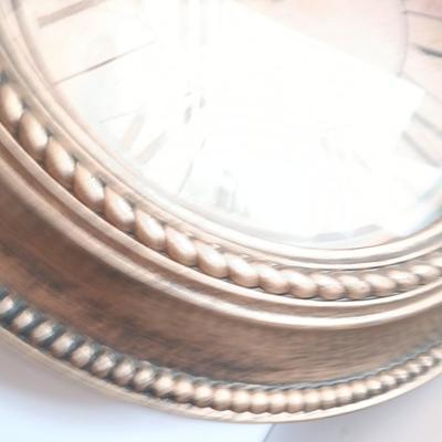 Roman numeral wall clock with woven metal vase decor