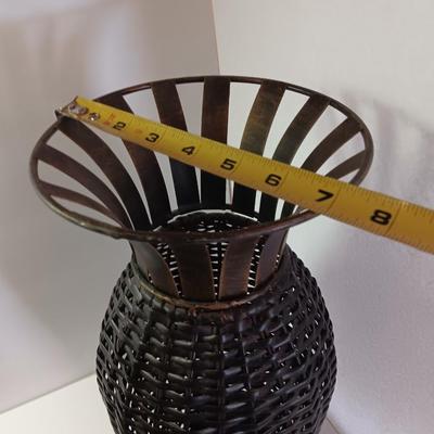 Roman numeral wall clock with woven metal vase decor