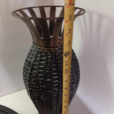 Roman numeral wall clock with woven metal vase decor