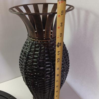 Roman numeral wall clock with woven metal vase decor