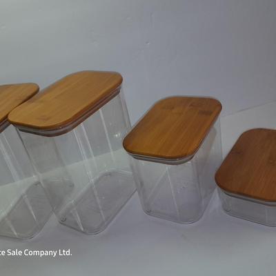 Four wooden bamboo lidded plastic food storage containers with an assortment of Kitchen hand towels