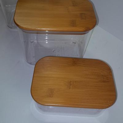 Four wooden bamboo lidded plastic food storage containers with an assortment of Kitchen hand towels