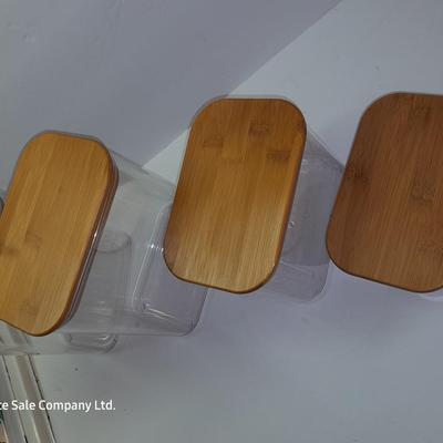 Four wooden bamboo lidded plastic food storage containers with an assortment of Kitchen hand towels