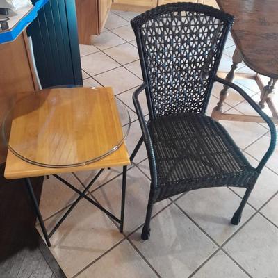 Metal framed end table with wood or glass top and a black woven plastic armchair