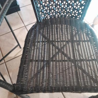 Metal framed end table with wood or glass top and a black woven plastic armchair