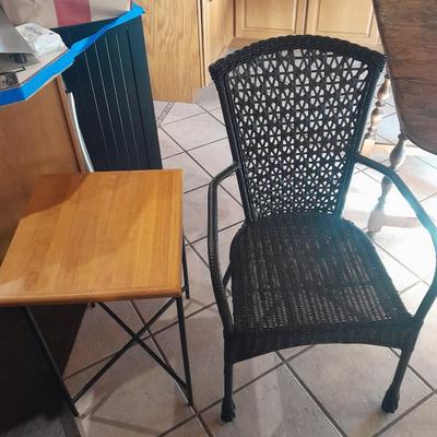 Metal framed end table with wood or glass top and a black woven plastic armchair