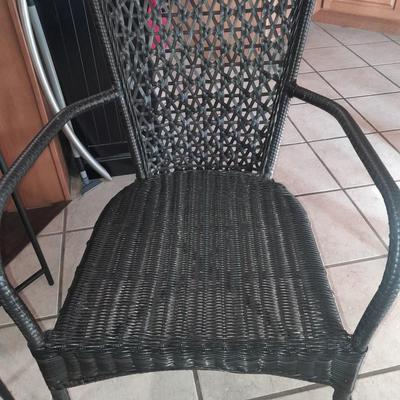 Metal framed end table with wood or glass top and a black woven plastic armchair