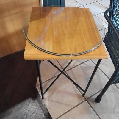 Metal framed end table with wood or glass top and a black woven plastic armchair