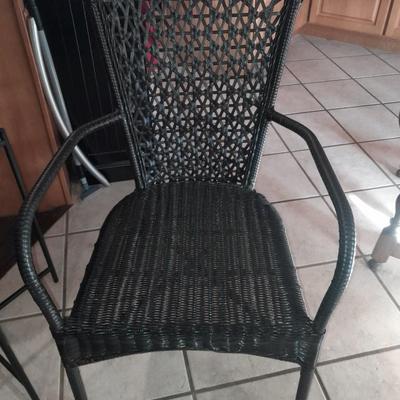 Metal framed end table with wood or glass top and a black woven plastic armchair