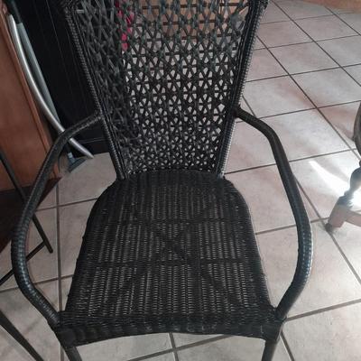 Metal framed end table with wood or glass top and a black woven plastic armchair