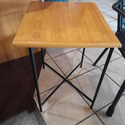Metal framed end table with wood or glass top and a black woven plastic armchair