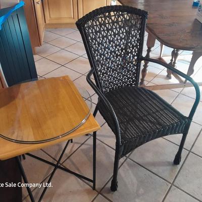 Metal framed end table with wood or glass top and a black woven plastic armchair