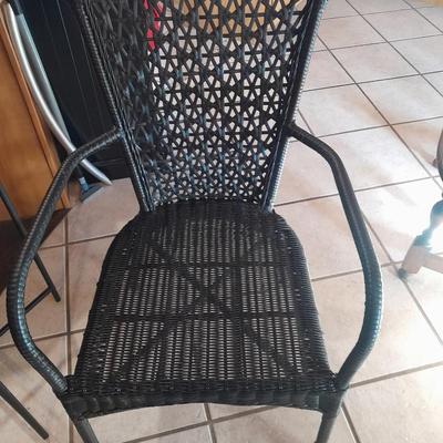Metal framed end table with wood or glass top and a black woven plastic armchair